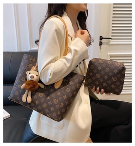 Detail of vintage tote bag with matching pouch and bear charm on office suit model