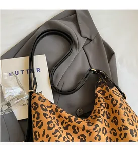 Detail of leopard print velvet shoulder bag with leather strap and golden hardware