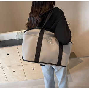 Detail showing the gray nylon material and embroidered logo on this large yoga tote bag