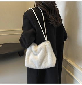 Close-up of fluffy white faux fur texture on minimalist winter shoulder bag with rope straps
