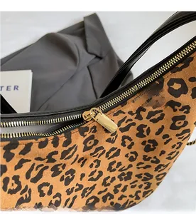 Close-up of leopard print handbag with a smooth golden metal zipper and velvet texture