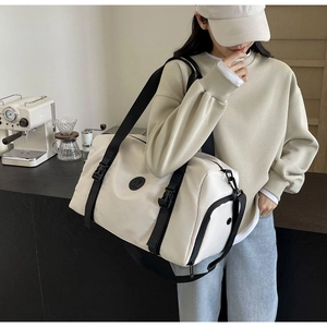 Detail of white travel bag side adjustable buckle and black strap contrast on nylon fabric