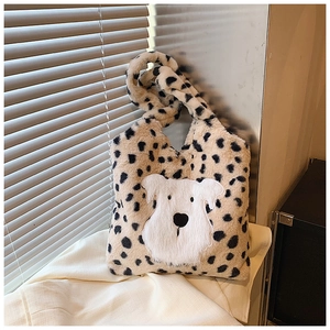 Détail d'un sac cabas en peluche léopard avec une applique de chiot blanc brodée