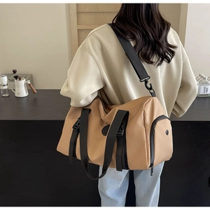 Detail of khaki nylon travel bag with heavy-duty black webbing and detachable shoulder strap