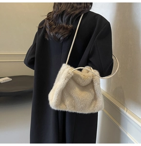 Close-up of off-white faux fur shoulder bag texture styled with a black winter coat