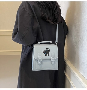Vue arrière du mannequin portant le sac à dos vintage bleu clair avec chat brodé