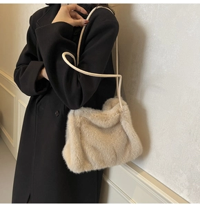 Detail of beige faux fur shoulder bag texture paired with a black winter wool coat