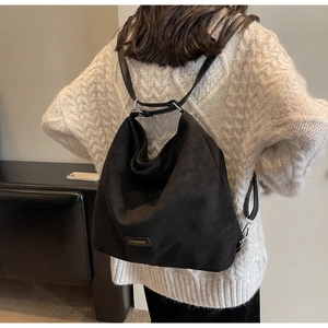Detail of black suede backpack with slim leather strap and fashion tag detail