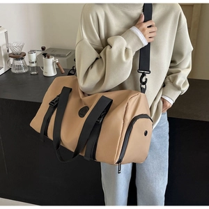 Detail of khaki barrel travel bag with adjustable strap and side pocket for fitness