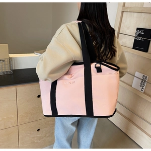Detail of pink canvas yoga tote bag featuring Ningjia embroidery and black reinforced edges