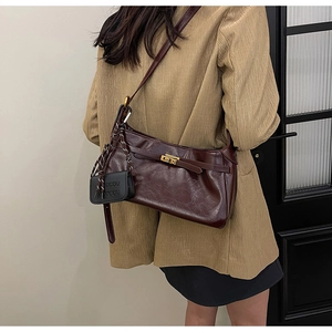 Rear view of a dark reddish-brown vintage leather baguette bag with a gold metal buckle