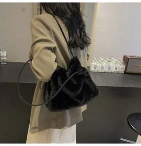 Close-up of black faux fur shoulder bag with soft plush texture and slim leather straps
