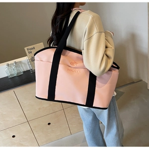 Detailed side view of pink and black yoga fitness bag showing large capacity on a model