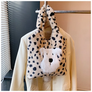 Détail du cabas en peluche avec taches léopard et écusson chiot blanc en fausse fourrure
