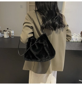 Detail of black faux rabbit fur shoulder bag showing fluffy texture and leather strap