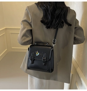 Vue détaillée du sac vintage noir avec broderie de chiot coloré et boucles en métal