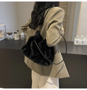 Detailed view of fluffy black faux fur shoulder bag with leather strap on model