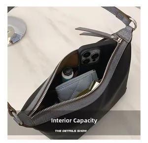 Detail view of the spacious interior of a dark grey shoulder bag with daily essentials