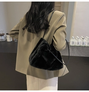 Close-up of fluffy black faux fur shoulder bag worn by model in minimalist setting