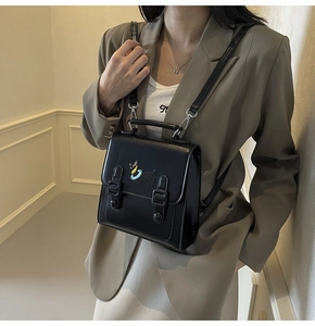 Gros plan d'un mini sac à dos en cuir PU noir avec motif teckel porté par un mannequin