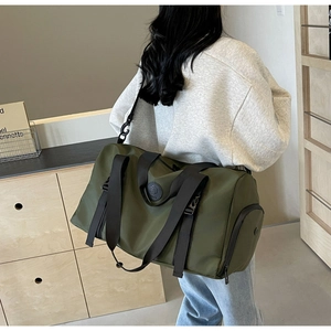 Detail view of army green travel bag featuring wide black straps and separate side pocket