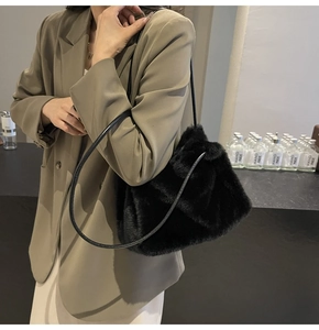 Close-up of soft black faux fur shoulder bag with leather strap for winter style