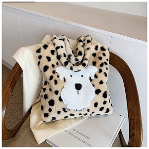 Détail d'un sac cabas en peluche avec fausse fourrure tachetée et broderie chien