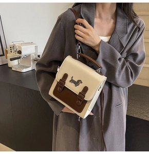 Détail d'un sac bandoulière beige et marron avec broderie teckel et sangles en similicuir