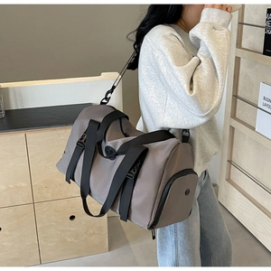 Side view of a grey high-capacity travel bag with black straps in a lifestyle scene