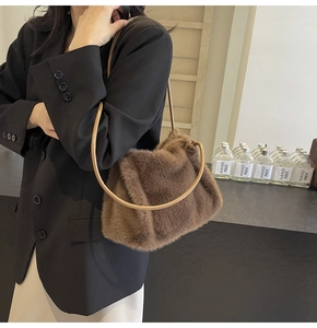 Detailed view of plush brown shoulder bag with circular handle on business casual outfit
