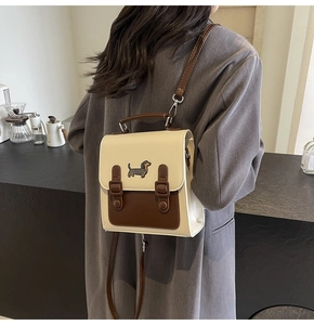 Détail d'un sac à dos vintage en similicuir avec broderie de teckel et design bicolore