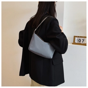 Rear 45-degree angle of a Morandi blue-grey nylon underarm bag with slim leather strap