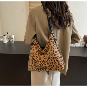 Detail of leopard print tote bag featuring a leather strap and metallic chain detail