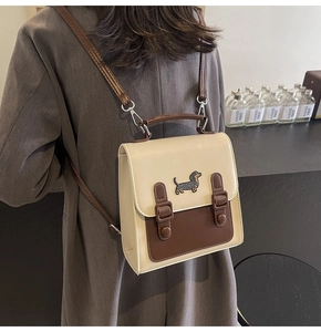 Détail du sac à dos rétro crème et marron avec écusson teckel et boucles en argent poli