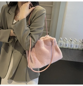 Detailed view of pink fuzzy plush shoulder bag texture on a model in autumn outfit