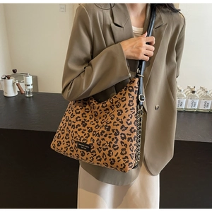 Detail of leopard print tote bag with premium leather logo tag and chain strap