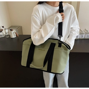 Close-up of lightweight green yoga bag with black straps and brand embroidery detail