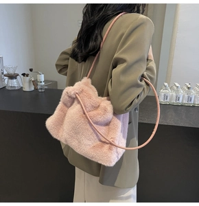 Detail of pink faux fur shoulder bag with soft plush texture and slim leather strap