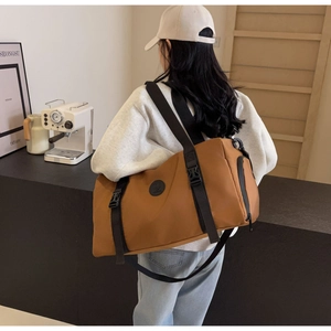 Detail of caramel travel bag with adjustable strap and side zipper pocket for fitness