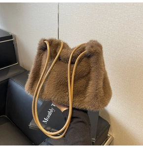 Detail of soft brown faux fur shoulder bag with slender light coffee leather handle