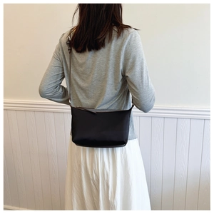 Rear view of minimalist black crossbody crescent bag on a model for daily commuting