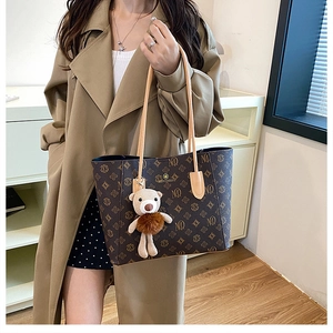 Detail of vintage monogram tote bag with MQ pattern and cute teddy bear charm