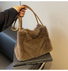 Close-up of fluffy brown faux fur tote bag showing soft texture and slim leather handles