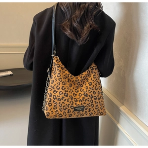 Detailed view of leopard print hobo bag with leather strap and decorative metal chain