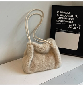 Close-up of soft beige faux fur shoulder bag with slender leather strap for winter