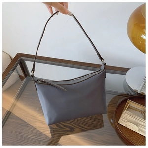 Detailed close-up of a minimalist grey nylon shoulder bag with premium matte texture