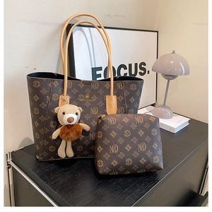 Detail of vintage brown printed tote bag set with matching pouch and plush bear charm
