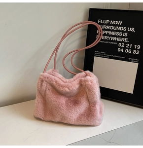 Close-up of soft pink faux fur texture and slim leather cord straps on a stylish tote