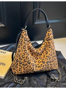 Leopard print leopard tote bag with chain strap displayed on a stylish leather jacket