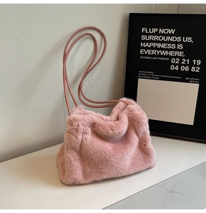 Detail of pink faux fur shoulder bag texture on marble surface with soft interior lighting